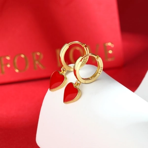 Macro view of S925 sterling silver heart earrings with red enamel and gold finish