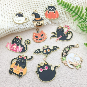 Close-up of assorted Halloween cat enamel charms with pumpkin and bat motifs