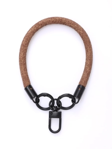 Detail of brown woven phone wrist strap featuring black metal carabiner and D-ring