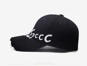 Close-up of distressed brim and white letter embroidery on a black vintage baseball cap
