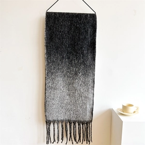 Close-up of extra thick scarf featuring black to light grey gradient with tassel fringe