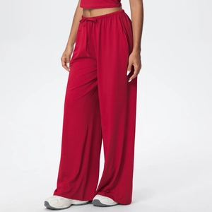 Detail of red drawstring lounge pants showing fluid drape and elastic high waistband