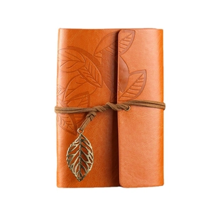 Vintage orange leather notebook with embossed leaf design and bronze leaf pendant