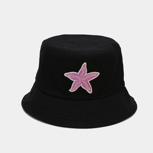 Detail of purple starfish embroidery on a black cotton bucket hat with clean stitching