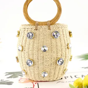 Handcrafted beige straw bucket bag with rhinestone embellishments and round woven handles