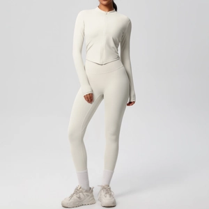 Détail d'un ensemble de yoga blanc crème avec veste à zip, passe-pouces et legging taille haute