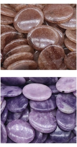 Close-up of polished amethyst and strawberry quartz stones for thumb massage