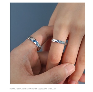 Detailed close-up of Van Gogh starry night couple rings on hand with blue enamel details