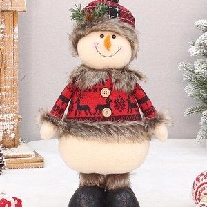Detail of Christmas snowman plush with knit sweater and red plaid hat in festive setting