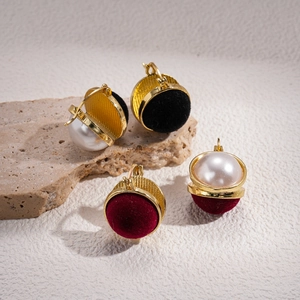 Retro geometric earrings with gold frames, pearls and velvet studs on textured stone