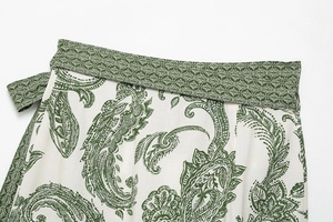 Detail of bohemian white shirt with green paisley floral print and cotton linen texture