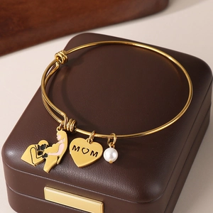 Detail of adjustable gold MOM heart bracelet with pearl charm on a jewelry box
