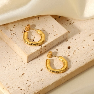 18K gold plated stainless steel lava texture C-shape hoop earrings on silk background