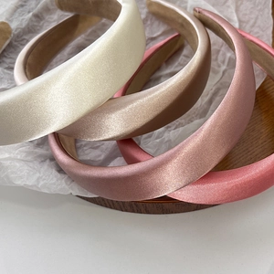 Detail of four padded satin headbands in cream, champagne, rose gold, and pink colors