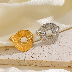Modern 18K gold plated hollow circular ring with radial stripes on elegant stone base
