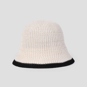 Detailed macro view of beige knit bucket hat texture with contrasting black brim edge