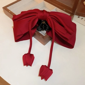 Détail d'une pince à cheveux à nœud satin rouge foncé avec pampilles tulipes sur bois