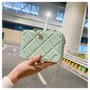 Detailed view of mint green PVC jelly bag featuring diamond lattice and golden flower detail