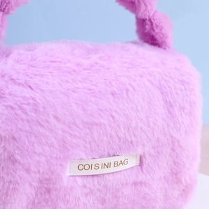 Detailed close-up of soft pink plush vanity bag featuring a COIS INI BAG woven label
