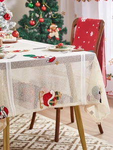 Detailed close-up of Santa Claus embroidery on beige lace Christmas table runner