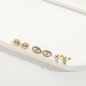 Three pairs of gold evil eye stud earrings with blue enamel and sparkling zircons
