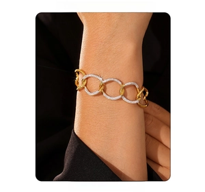 Detailed macro view of interlocking gold and silver rings with crystals on a link bracelet