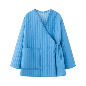 Detail of bright blue quilted jacket featuring V-neckline and stylish side tie closure