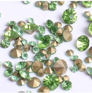 Detailed macro view of sparkling green and gold faceted rhinestones for nail art DIY