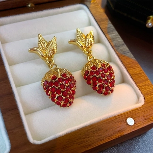 Vintage style gold strawberry earrings with red rhinestones in a white velvet jewelry box