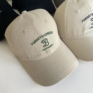 Broderie détaillée 'FORGETSADNESS' et 'B' sur une casquette en coton beige