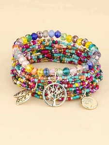 Macro detail of Bohemian multilayer beaded bracelets with Tree of Life and leaf charms