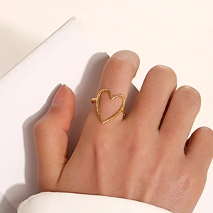 Gold heart-shaped open ring with unique hammered texture on an elegant female hand