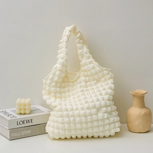 Close-up of the white popcorn texture fabric and pleated design on this tote bag