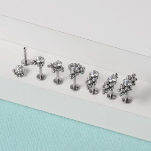 Detailed close-up of G23 titanium labret studs with opal and clear zircon settings