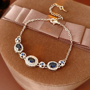 Detail of silver vintage bracelet with deep blue oval gemstones and clear diamonds on gift box