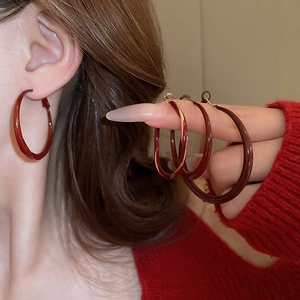 Macro view of burgundy glaze hoop earrings showing the high-gloss metallic finish