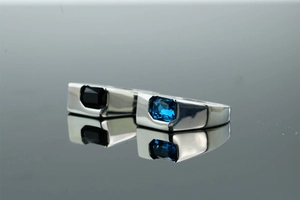 Macro detail of polished rings with rectangular black and deep blue zircon gemstones