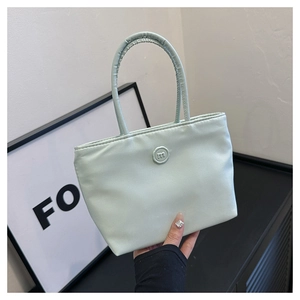 Detail van de mintgroene nylon emmertas met geplooide handgreep en rond m-logo-embleem