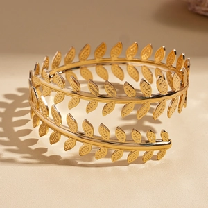 Detail of golden laurel leaf arm cuff with delicate vein textures and metallic finish