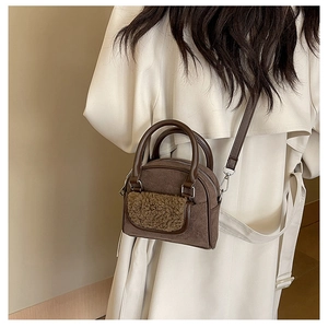 Detail of plush faux fur texture on a vintage dark brown suede handbag with metal hooks