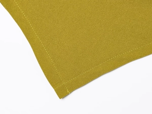 Dettaglio macro del tessuto elasticizzato giallo senape e finitura delle cuciture piatte