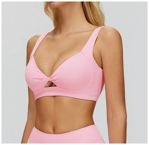 Dettaglio del reggiseno yoga rosa chiaro con design a incrocio e tessuto elastico