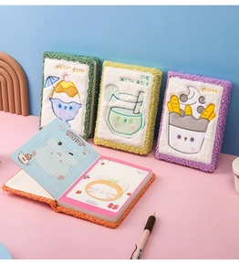 Detalle de cuadernos de peluche con bordado de postre y páginas interiores rayadas