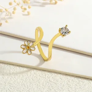 Detail of adjustable gold ring with white enamel daisy and sparkling zircon stone