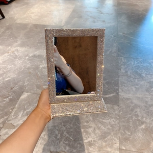 Detail of silver foldable makeup mirror with dense rhinestone sparkling finish
