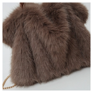 Detail of soft dark brown plush faux fur fabric with elegant gold metal chain strap