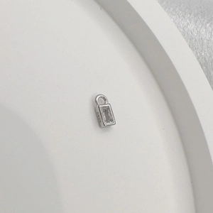 Macro shot of rectangular S925 sterling silver pendant with clear zircon and hallmark