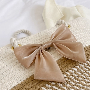 Handwoven straw tote bag with beige and coffee stripes and a gold silk bow detail