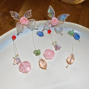 Macro view of crystal butterfly wings with rose fabric and multi-color beaded tassels