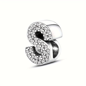 Close-up of silver-plated S-shaped letter charm with sparkling pavé micro-inlaid crystals